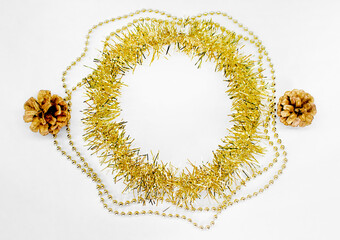 Fototapeta na wymiar Christmas decorations of yellow and golden color on a white background - chain of balls, beads, round circle of tinsel, two bumps. New year concept