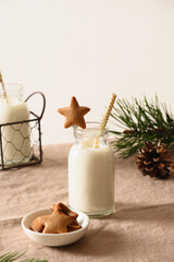 Homemade cookies in shape of star and milk for Santa Claus and Christmas tree on table. Close up.