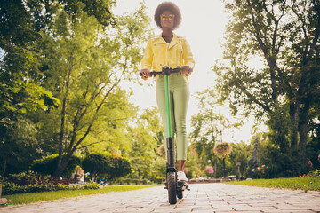 Full length body size view of her she attractive slender fit slim thin wavy-haired girl wearing leather jacket riding electric scooter enjoying autumn fall fresh air healthy life dream outside outdoor