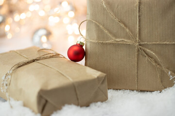 Prezenty Boże Narodzenie na śniegu, białe tło z lampkami i światełkami. Świąteczny klimat z dekoracją - obrazy, fototapety, plakaty