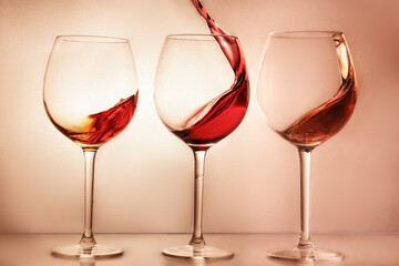 splashes wine at bright beige background 