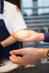 Woman holding dough in her hand at a cooking class