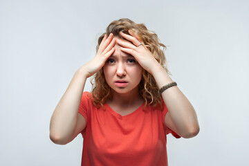 Photo of upset woman grabbing her head and rubbing temples because of headache. Human emotions facial expression concept