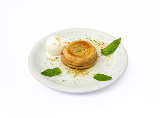 Semolina dessert and ice cream in white plate, standing on isolated background.