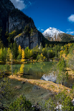 autumn forest at Lac de Derborence with reflection in Valais