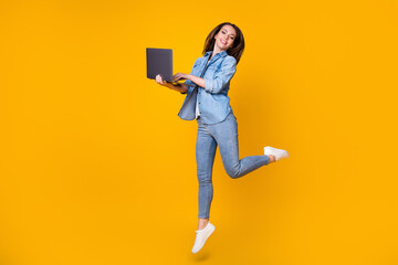 Full length body size view of her she nice slim fit cheerful successful learner jumping walking using laptop watch video tutorial university isolated bright vivid shine vibrant yellow color background