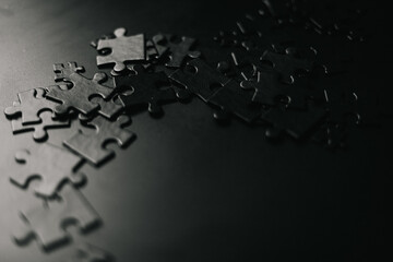 frame formed of black puzzles. Photo of black puzzles on a black background, business background