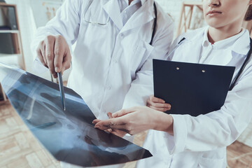 Doctors stand together and look at x-rays.