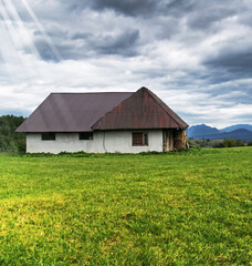 Obraz premium At the farm. Barn in a beautiful mountain area. Valleys, mountains and green grass.