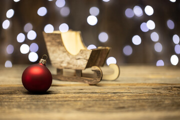 Dekoracja świąteczna - Boże Narodzenie, na stole, w oddali sanie Św. Mikołaja. 