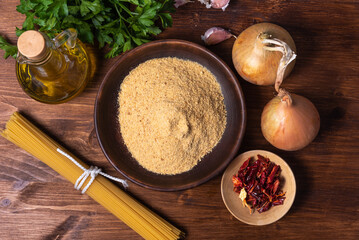 Cooking spaghetti alla carrettiera, pasta with onions and breadcrumbs - ingredients on rustic...