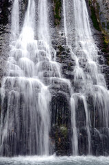 Naklejka na ściany i meble Vertical image of a waterfall in a river