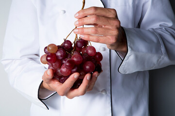 chef with  red grapes in his hands