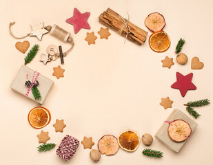 Fototapeta na wymiar Festive Xmas decorations, homemade gingerbread cookies, giftas, fir branches on natural beige background.