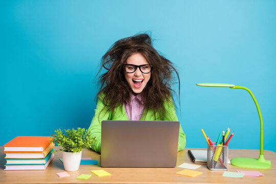 Portrait Of Crazy Messy Hair Girl Student Sit Desk Work Remote Laptop Wear Green Shirt Isolated Over Blue Color Background