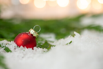Czerwona bombka na śniegu. Dekoracja na Boże Narodzenie, świąteczny klimat.