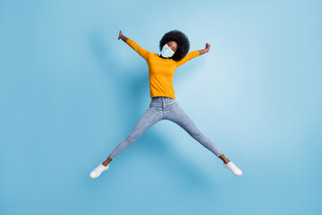 Photo portrait full body of woman jumping up spreading like star wear medical mask isolated on pastel blue colored background