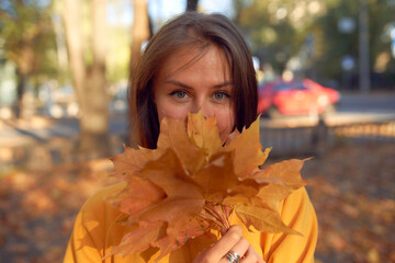 Beautiful caucasian young woman walking and having fun outdoors in autumn time. Bright yeallow...