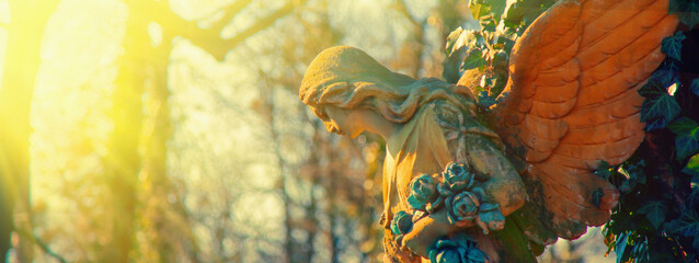 Antique statue of gold angel in rays of hope and sun. Metaphor image.