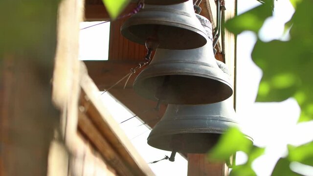 A person rings the several bells pulling by ropes