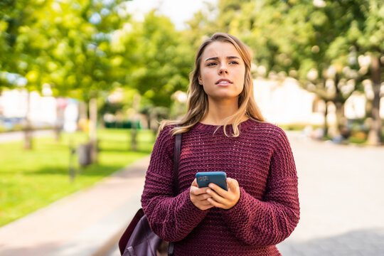 Young Woman Tourist Using Online City Guide On Smartphone Gps In Urban Street Searching Locations.