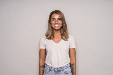 Obraz premium Young positive woman with long hair wearing t-shirt and jeans isolated on white background
