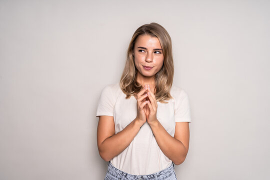 Portrait Of Sly Woman Looking With Cunning Eyes Holding Her Hands Together Trying To Ask Something In Sly Manner. Cute Female Expressing Her Slyness In Front Of Camera