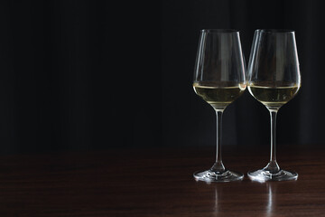 two glasses white wine in hotel room. Close-up a Glass of white wine is on the table. Warm cozy atmosphere, festive table, a glass of champagne on the table.