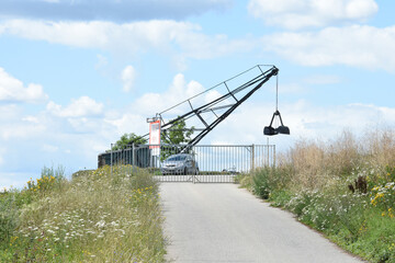 old crane of brickworks on the dyke of river Rhine