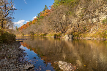 Fototapeta na wymiar Root River In Autumn - A scenic river next to a cliff.