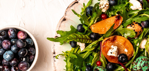 Easy recipe for summer salad with goat cheese, grilled apricots, arugula, berries, close-up on a plate