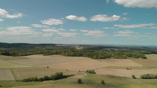 Aerial landscape of farmland and countryside in Germany, bright blue sky day.