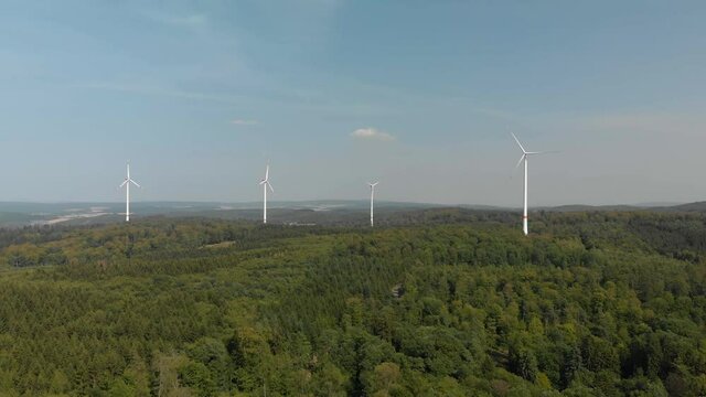 Wide aerial landscape of wind turbines, located in the German countryside, bright summers day.