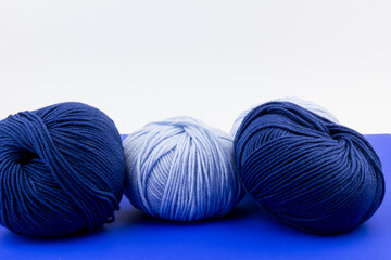 woolen merinos blue threads on blue and white background. natural wool. knitting. background