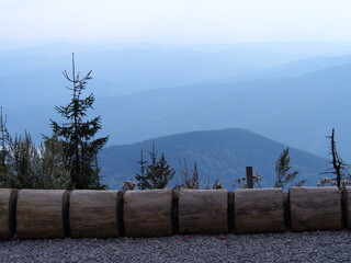 view from Lysá hora to the mountain landscape with trees and a bicycle stand from a log in the...