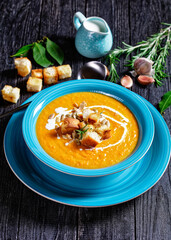 Comforting autumn pumpkin soup in a blue plate