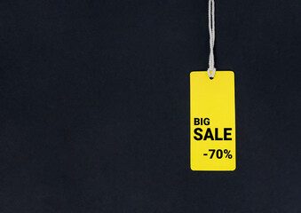 Yellow label tag with inscription sale at black background.