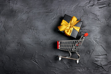 Shopping trolley and gift box with gold ribbon on black background. Holiday shopping and sale or...