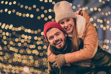 Photo of bonding couple boyfriend piggyback girlfriend under x-mas tradition christmas outside...