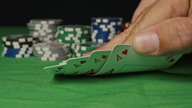 Four aces in his hands on the table