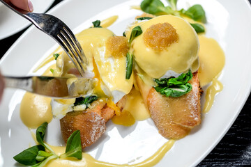 bruschetta with spinach and poached egg, cut with cutlery
