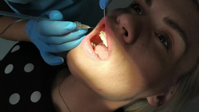 Dentist giving anesthesia to his patient in a close up portrait