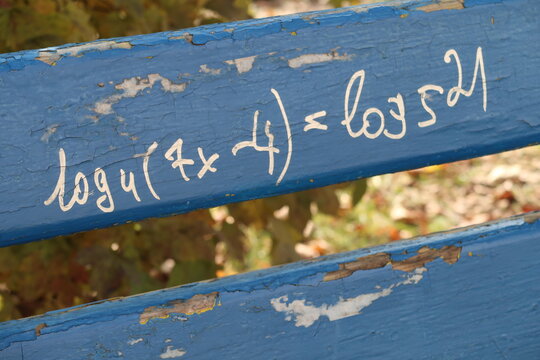 Mathematical equation written on a wooden park bench