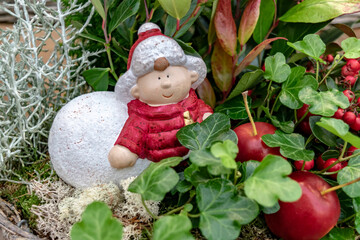 Christmas winter composition with red apples, red berries and green ivy. Cozy winter garden floral arrangement. 