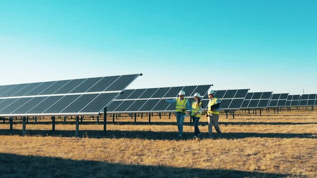 Walk around inspection at solar plant. Solar power plant workers, solar energy industry concept.