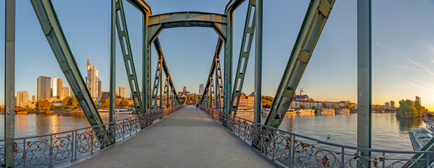 eiserner Steg, famous iron footbridge crosses river Main in Frankfurt with skyline in morning light - obrazy, fototapety, plakaty
