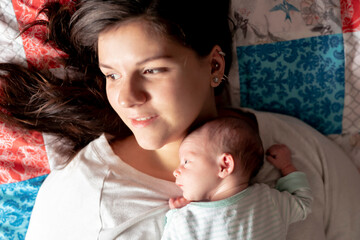 A Portrait of a beautiful mother with her newborn baby in the bedroom