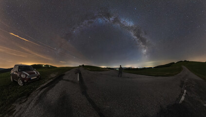 At the crossroads of two roads, decide where to go. Milky Way in the night sky.
