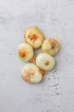 Top View of White Cipollini Onions on a Cement Background