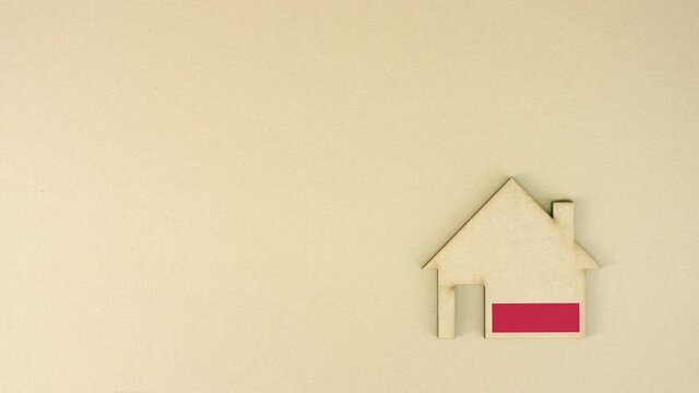 Placing cardboard home icon with printed flag of Poland. National real estate market concept